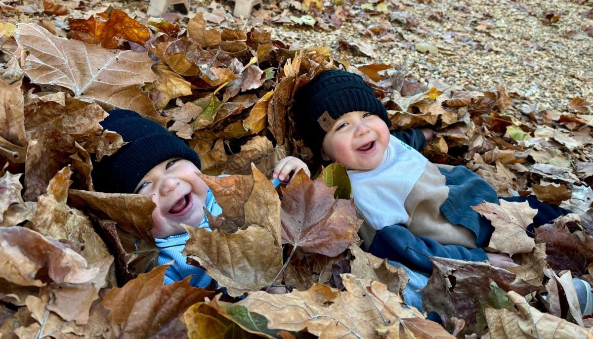 Two babies in a pile of leaves